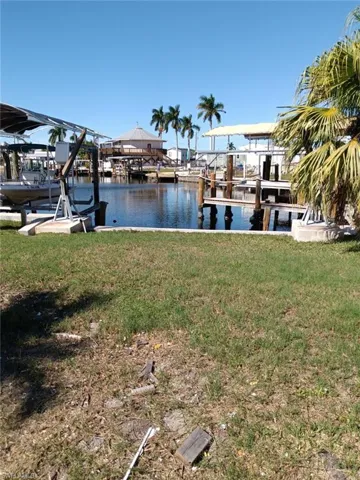 View of dock with a yard and a water view