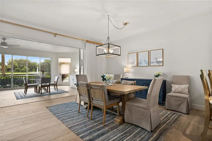 Wood-finish flooring, recessed lighting, and a linear chandelier illuminate this interior space