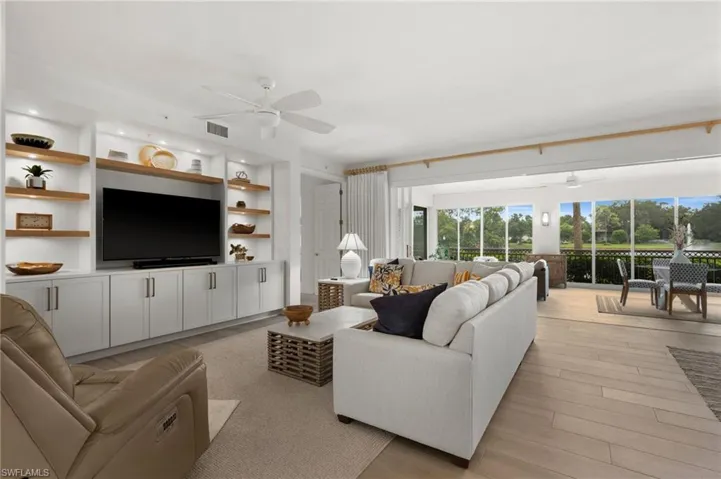 Built-in media center with wood-finish shelving, recessed lighting, and white cabinetry