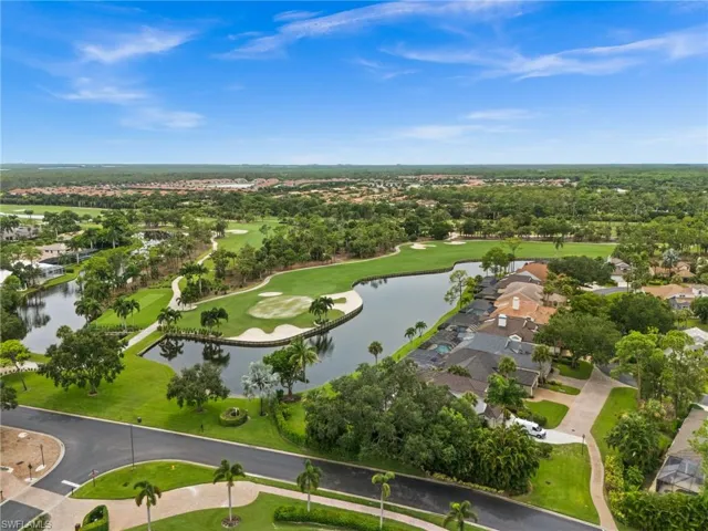 Expansive golf course and water features, lush green landscaping, mature trees, and residential properties with tiled roofs