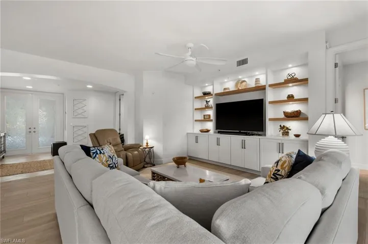 Integrated entertainment center with built-in cabinetry and open wood-finish shelving
