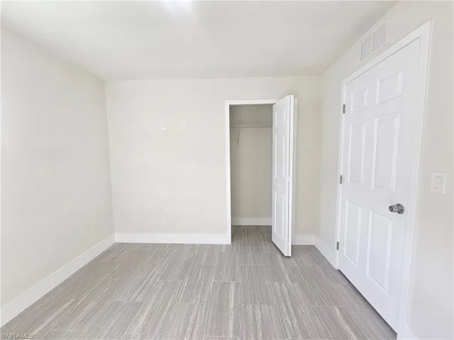 Unfurnished bedroom featuring wood finish floors and a closet