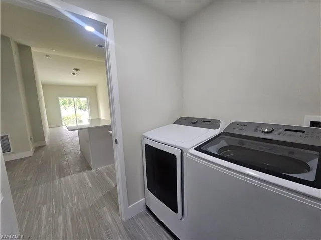 Laundry room featuring light wood-style floors and independent washer and dryer