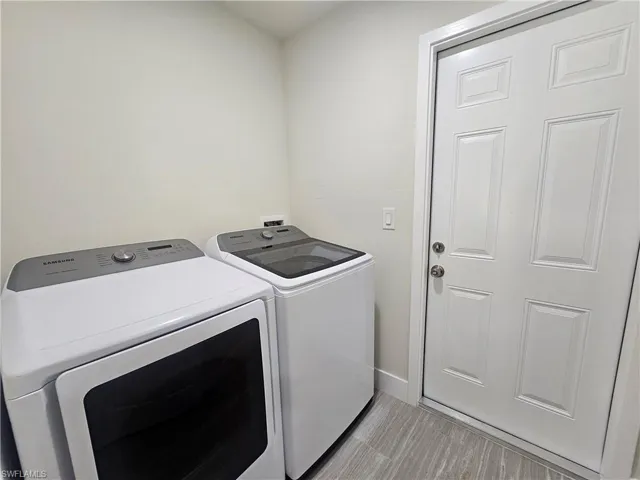 Laundry room with washer and dryer and baseboards