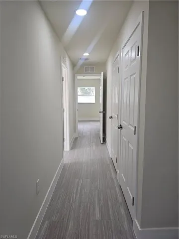 Hallway with baseboards and recessed lighting