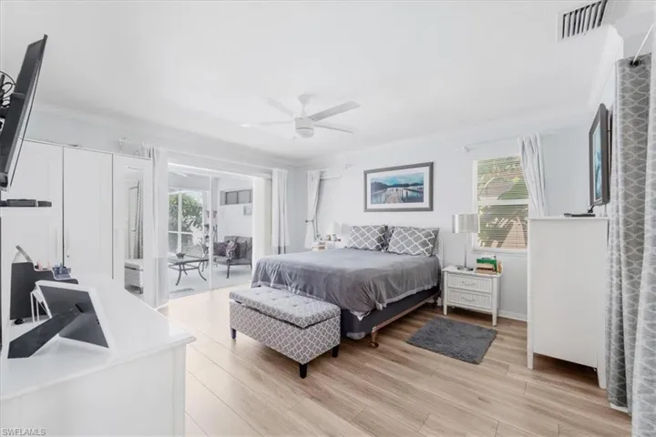 Bedroom featuring ornamental molding, access to outside, light wood-style floors, and a ceiling fan