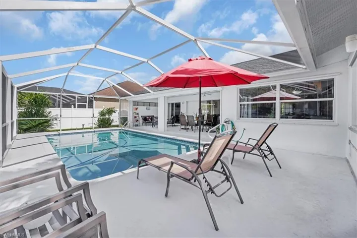 View of swimming pool featuring a patio and glass enclosure