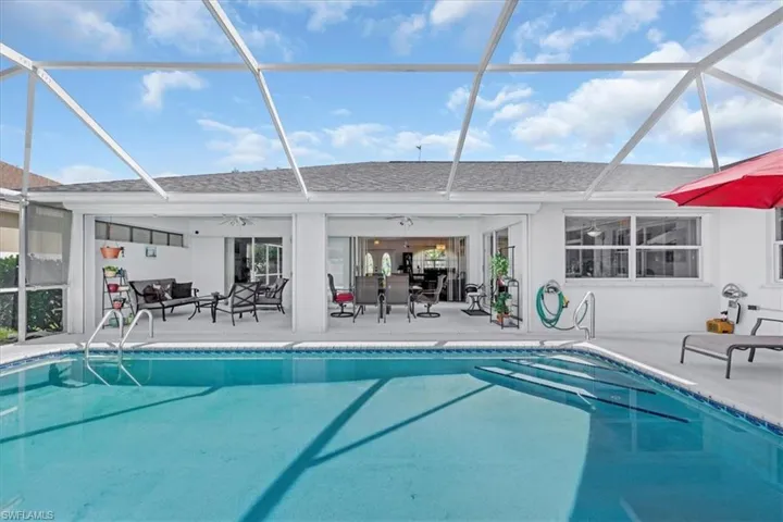 Outdoor pool with a patio area and glass enclosure