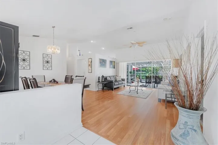 Living area with a chandelier, ceiling fan, and light wood-type flooring