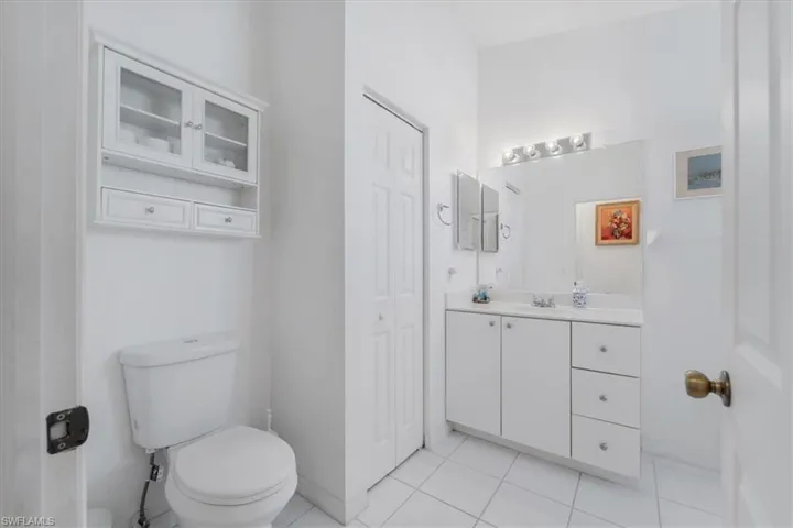 Bathroom with vanity, a closet, and tile patterned floors