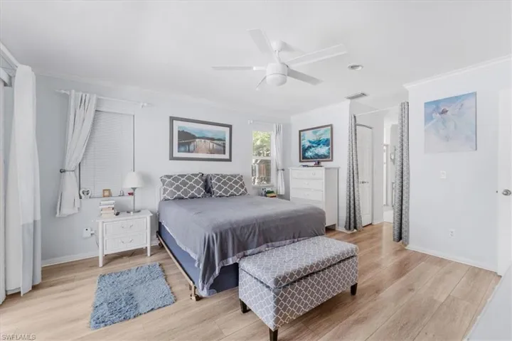 Bedroom featuring crown molding, light wood-style floors, and ceiling fan