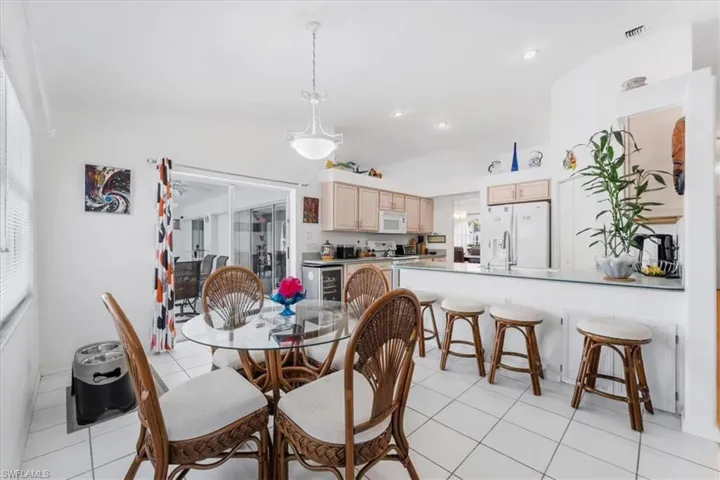 Dining space with light tile patterned floors and recessed lighting