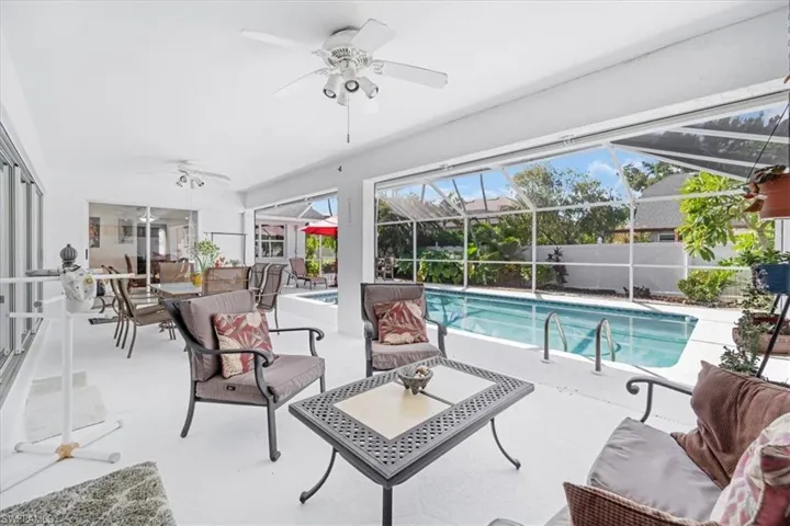 View of swimming pool with a ceiling fan, a patio area, outdoor lounge area, and a lanai