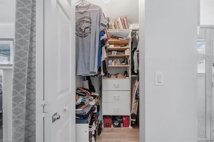 Walk in closet with wood finished floors