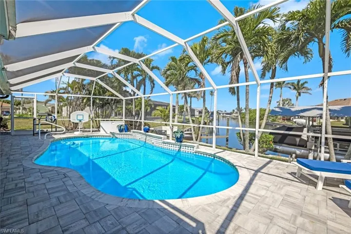 Pool featuring glass enclosure and a patio