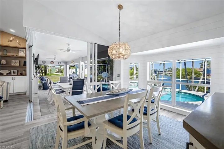 Dining space featuring lofted ceiling, light wood finished floors, a chandelier, and a wealth of natural light