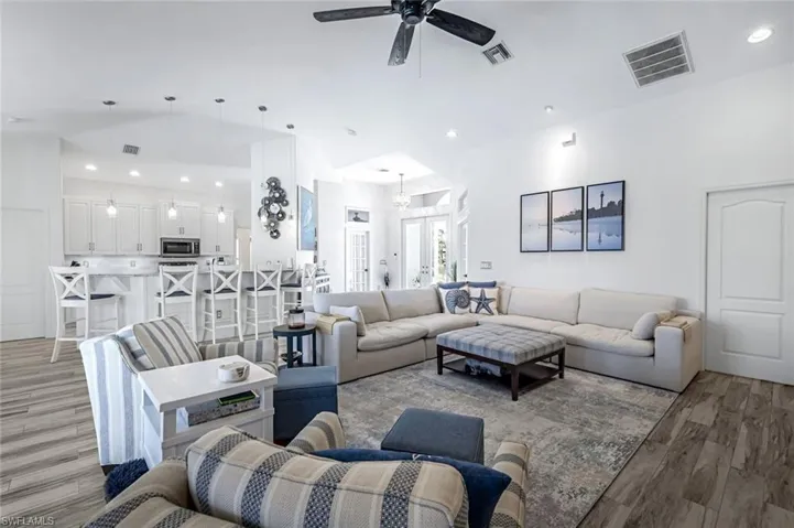 Living area with light wood-type flooring, visible vents, and recessed lighting