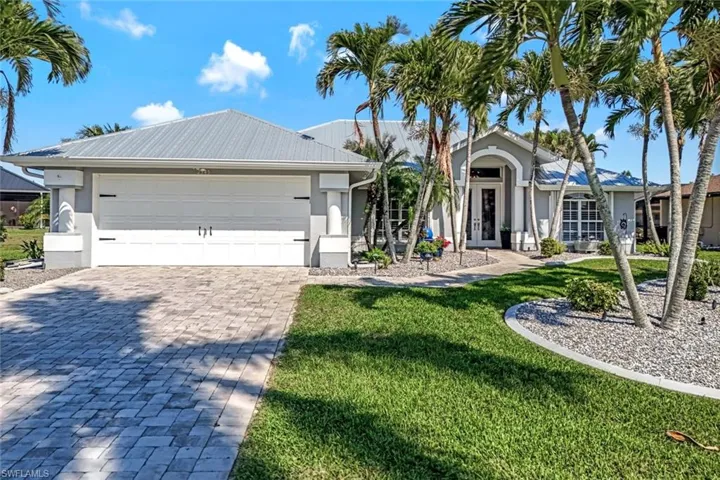 Single story home with a garage, stucco siding, decorative driveway, french doors, and a front yard