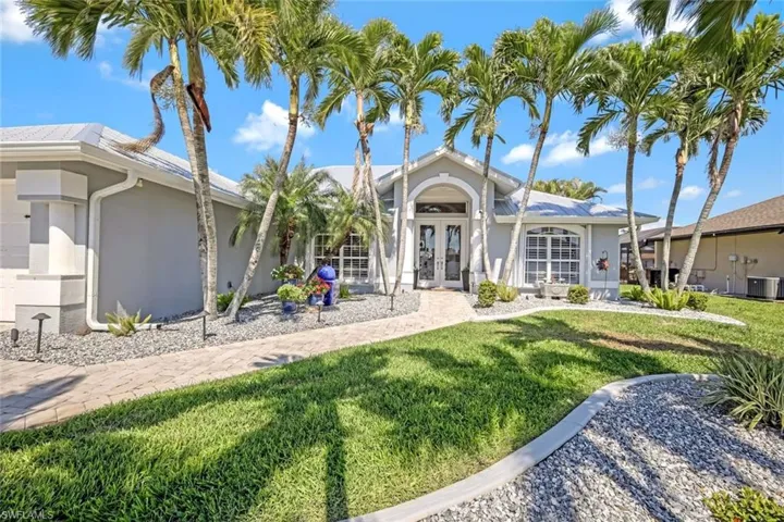 View of front of house featuring french doors, a front yard, central AC unit, and stucco siding
