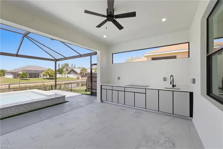 View of patio / terrace featuring an outdoor hot tub, a ceiling fan, a lanai, a residential view, and a sunroom