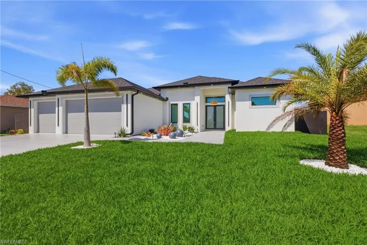Prairie-style house with a front yard, stucco siding, concrete driveway, and a garage