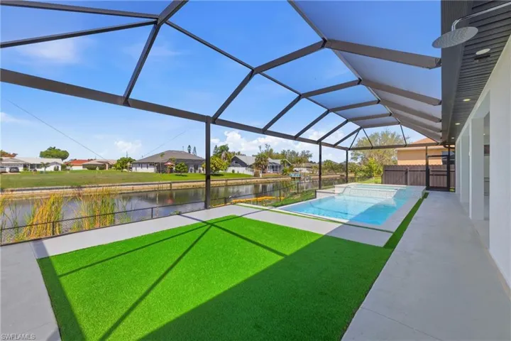 Integrated pool / hot tub featuring a fenced backyard, a sunroom, a residential view, a patio area, and glass enclosure