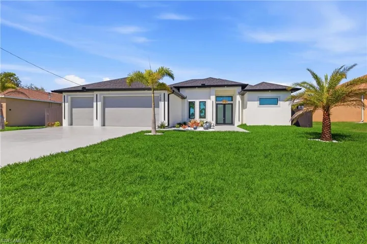 Prairie-style house with a front yard, driveway, stucco siding, and a garage