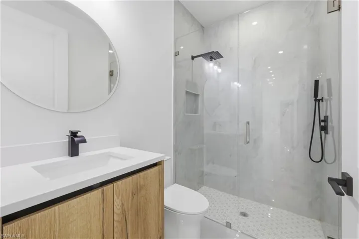 Bathroom with vanity and a marble finish shower