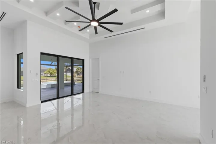 Spare room with light marble finish flooring, a ceiling fan, recessed lighting, and coffered ceiling