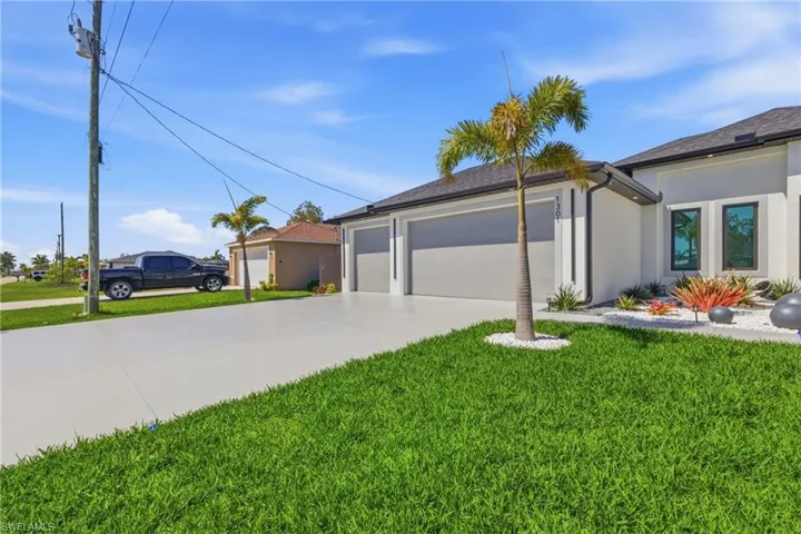 View of home's exterior with a garage, concrete driveway, a yard, and stucco siding