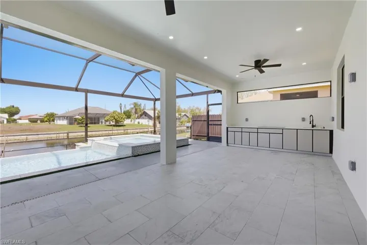 View of patio / terrace featuring a ceiling fan, a sunroom, a pool with connected hot tub, a residential view, and a lanai