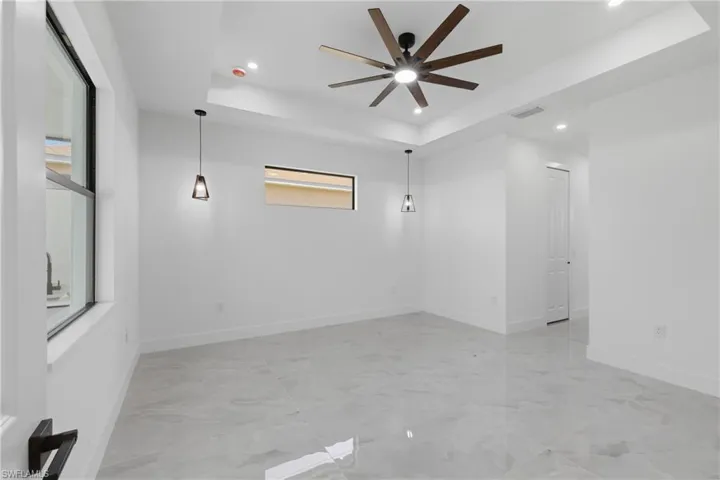 Empty room with recessed lighting, a tray ceiling, and a ceiling fan