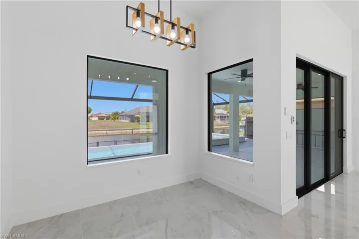 Unfurnished dining area featuring healthy amount of natural light, light marble finish flooring, and a residential view