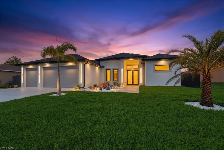Prairie-style house with stucco siding, a front lawn, a garage, and concrete driveway