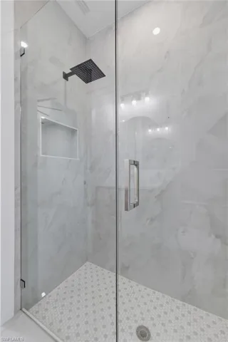 Full bath with a marble finish shower