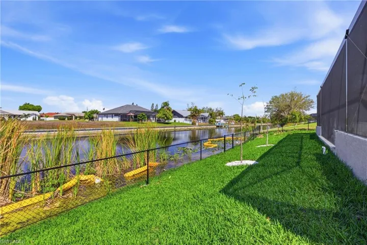 Fenced backyard with a sunroom, a residential view, a water view, and glass enclosure