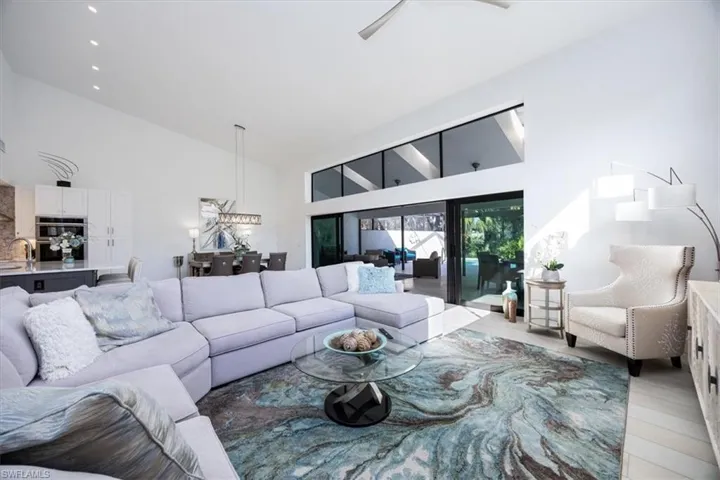 Living room featuring hardwood / wood-style floors, high vaulted ceiling, and ceiling fan