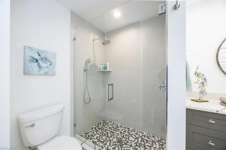 Bathroom featuring vanity, an enclosed shower, and toilet