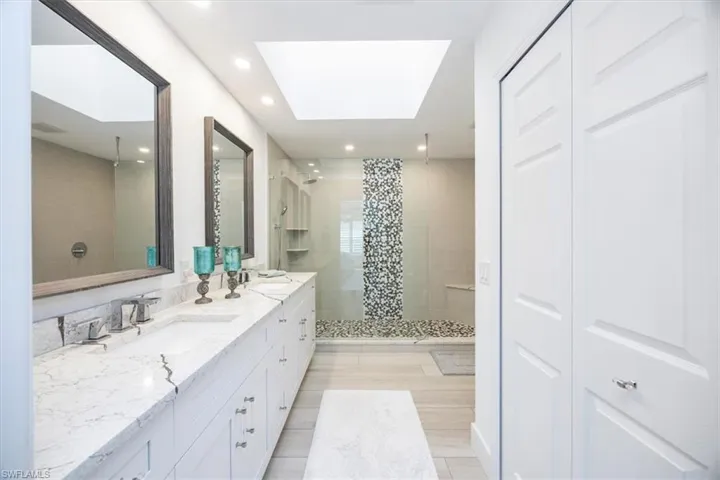Bathroom featuring vanity, a skylight, and an enclosed shower