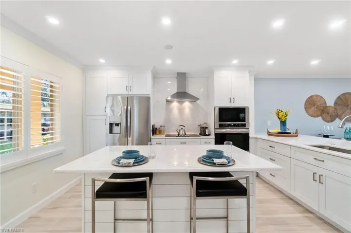 Breakfast island with white marble and shiplap accent offers additional dining space