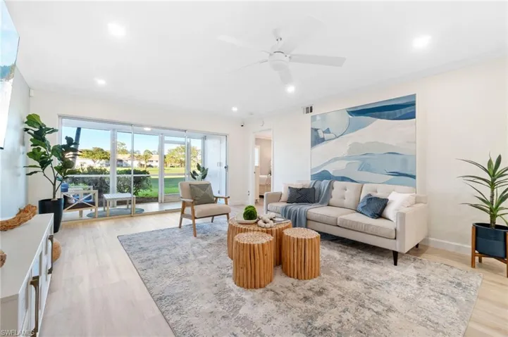 Living room with luxury vinyl flooring, ceiling fan, and ornamental molding and fresh paint throughout the unit