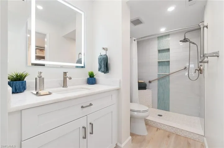 Stunning marble countertops, white shaker cabinets, shower fog-free mirrors