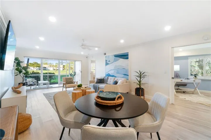 Dining area looking out through the main living space to the beautiful views of the lush golf course.  This unit is light and bright.  Freshly painted throughout and luxury vinyl throughout
