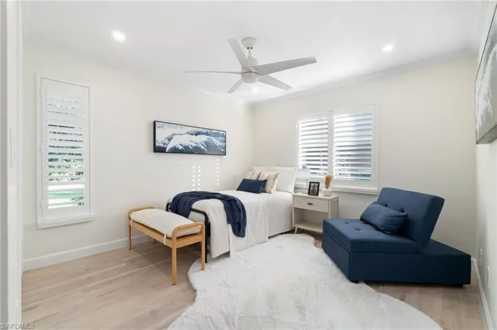Guest bedroom offers plenty of natural light, recess lighting, and plantation shutters