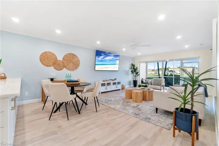 Open floor plan with dining area, spacious living area boasting long golf course and lake vistas
