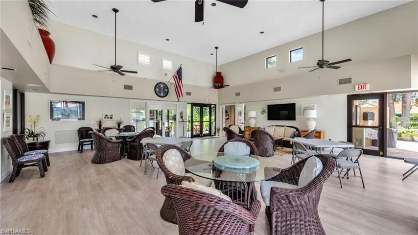 Dining room featuring a high ceiling, light wood-style floors, a ceiling fan, and french doors