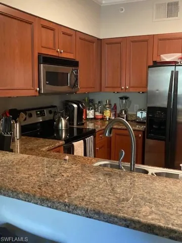 Quartz countertop with three stools, microwave, range, dishwasher, refrig with ice maker and water dispenser, garbage disposal