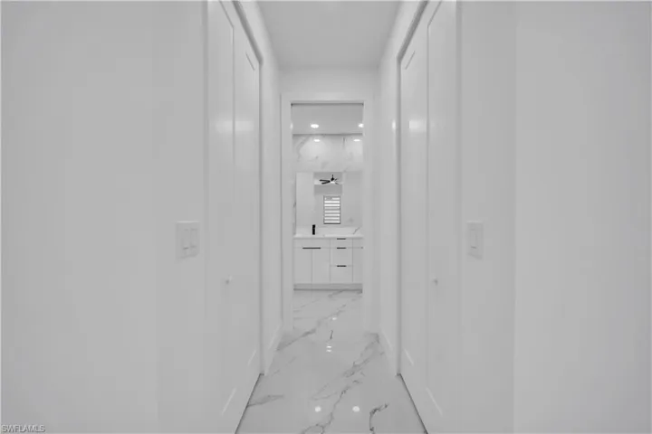Hall featuring recessed lighting and light marble finish floors