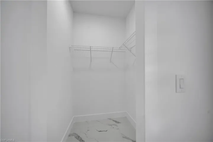 Walk in closet with light marble finish floors