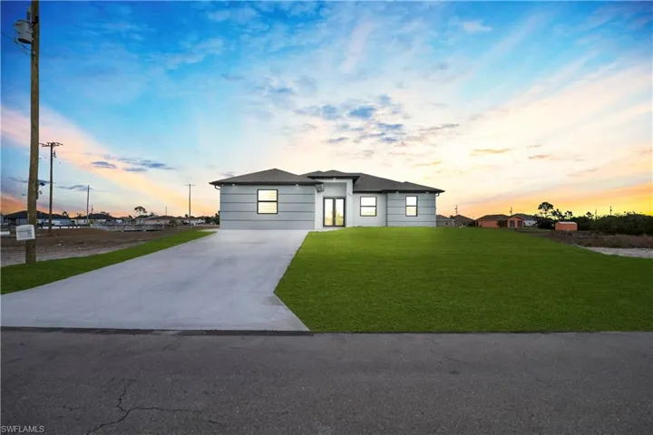 View of front of house with a front yard and concrete driveway